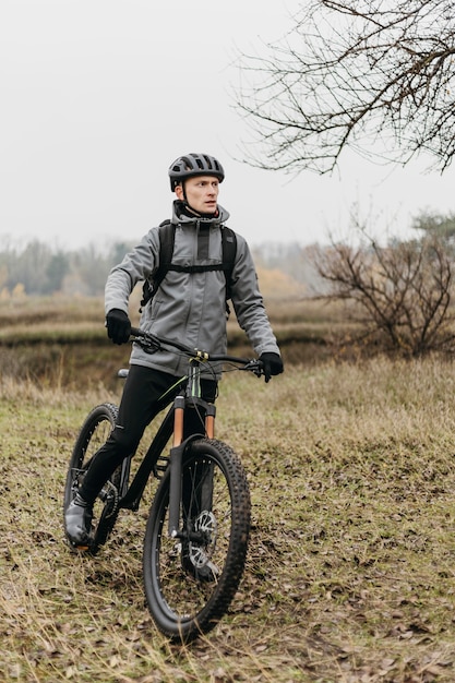 Vooraanzicht van de mens met een fiets in de bergen