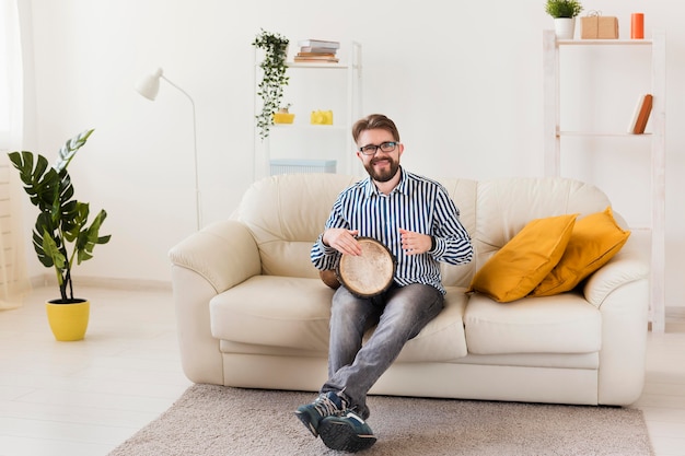 Vooraanzicht van de mens op de sofa met trommel