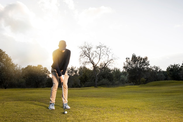 Gratis foto vooraanzicht van de mens op het met gras begroeide golfgebied