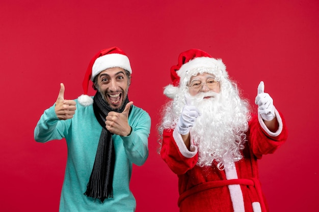 Vooraanzicht van de oude kerstman met een man die op de rode muur staat