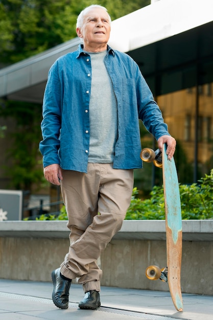 Vooraanzicht van de oude man met skateboard