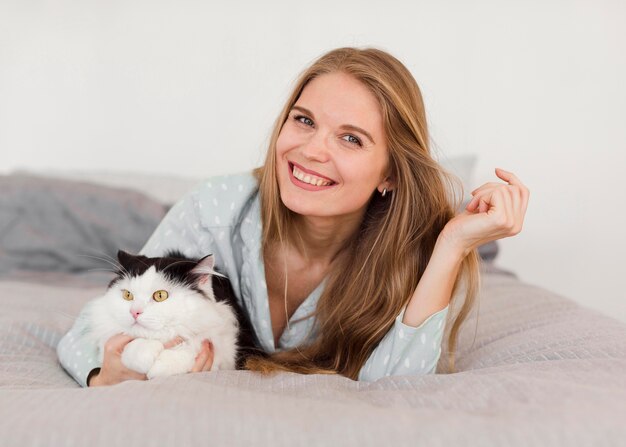 Vooraanzicht van de vrouw in bed met pyjama en kat