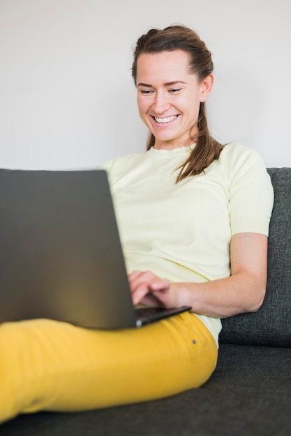 Gratis foto vooraanzicht van de vrouw zittend op de bank