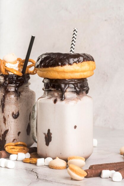 Vooraanzicht van desserts in potten met pretzels en donuts