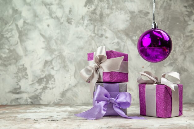 Vooraanzicht van drie kerstcadeaus voor familieleden en een decoratieaccessoire op ijsachtergrond