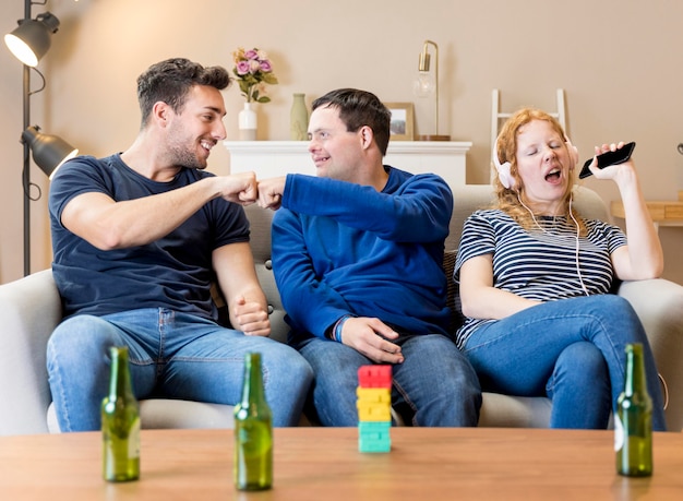 Vooraanzicht van drie vrienden die samen thuis pret hebben