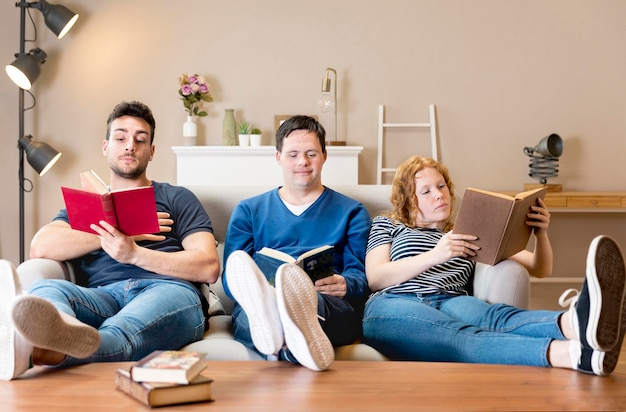 Vooraanzicht van drie vrienden thuis met boeken