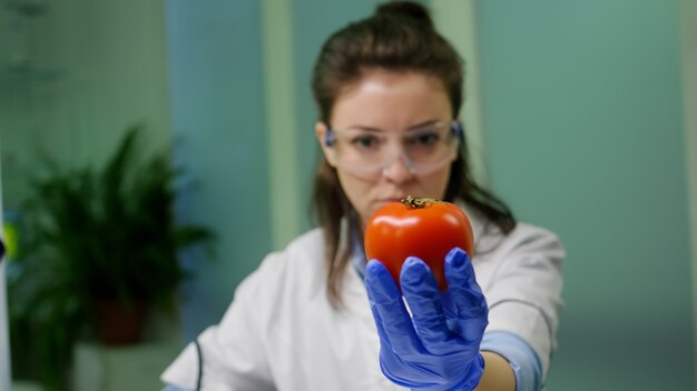 Vooraanzicht van een bioloog-onderzoeker die peper analyseert die is geïnjecteerd met chemisch dna voor wetenschappelijk landbouwexperiment. Farmaceutische wetenschapper werkzaam in microbiologisch laboratorium