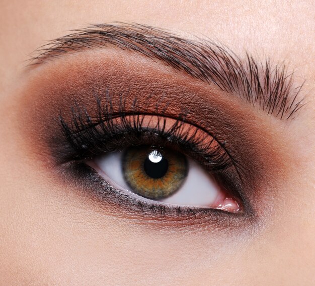 Vooraanzicht van een close-up vrouwelijk oog met bruine oogschaduwsamenstelling