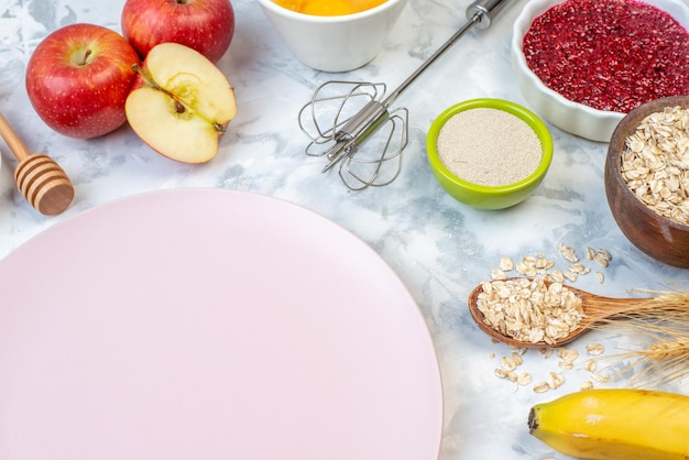 Vooraanzicht van een lege witte plaat en vers gezond voedsel op een tweekleurige achtergrond Premium Foto