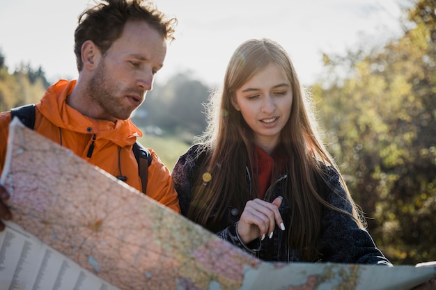 Vooraanzicht van een paar raadplegende kaart tijdens een roadtrip