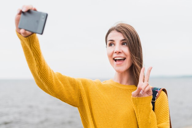 Vooraanzicht van een solo reizende vrouw die een selfie neemt