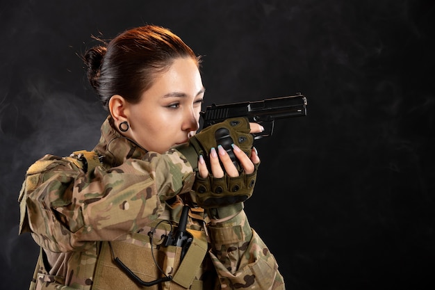 Vooraanzicht van een vrouwelijke soldaat die een pistool richt in een uniforme krijger Palestina tankoorlog