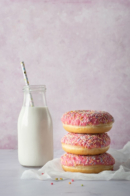 Vooraanzicht van geglazuurde donuts met besprenkeld en melk fles