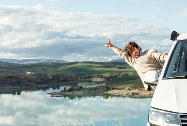 Vooraanzicht van gelukkig man genieten van de natuur tijdens een roadtrip