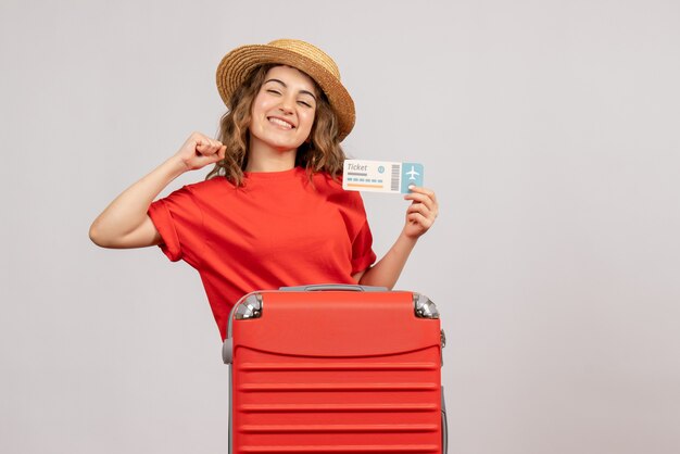 Vooraanzicht van gelukkig vakantiemeisje met haar valise holdingskaartje