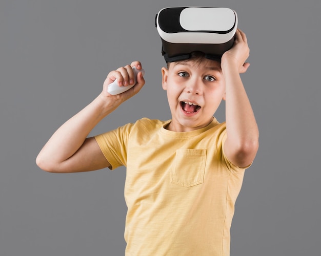 Gratis foto vooraanzicht van gelukkige jongen die virtuele werkelijkheidshoofdtelefoon draagt
