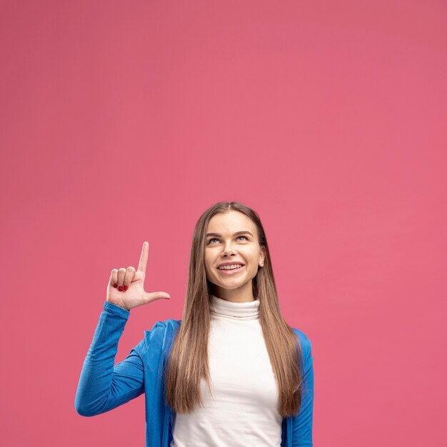 Vooraanzicht van gelukkige vrouw die omhoog wijst