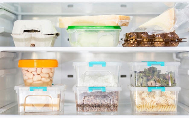 Vooraanzicht van georganiseerde plastic voedselcontainers in koelkast