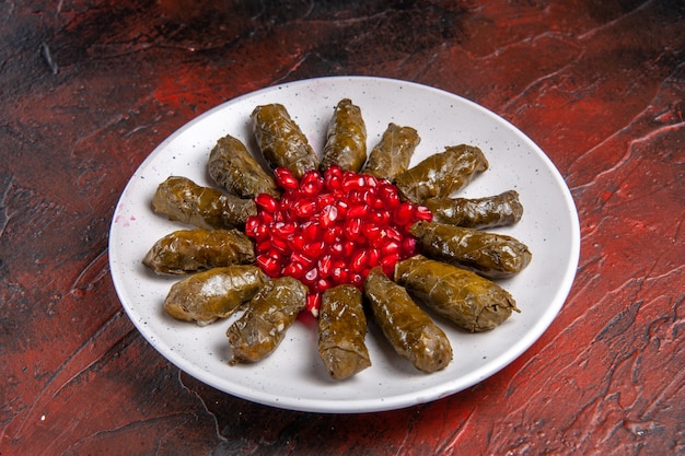 Gratis foto vooraanzicht van groene blad dolma met granaatappels op donkere ondergrond