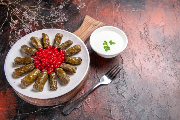 Vooraanzicht van groene blad dolma met yoghurt op donkere ondergrond