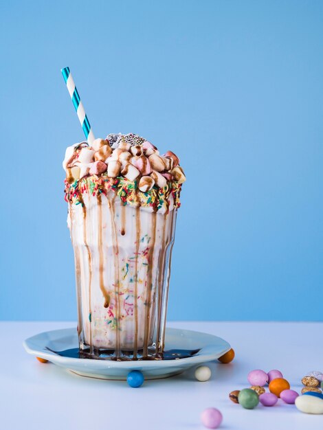 Vooraanzicht van heerlijke milkshae met blauwe achtergrond