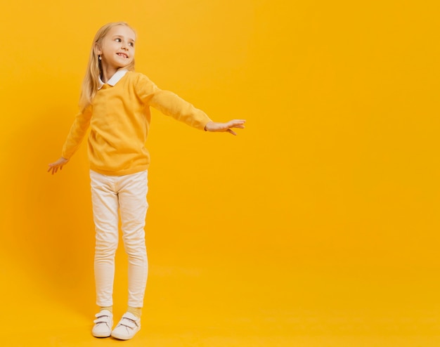 Gratis foto vooraanzicht van het gelukkige meisje stellen met exemplaarruimte