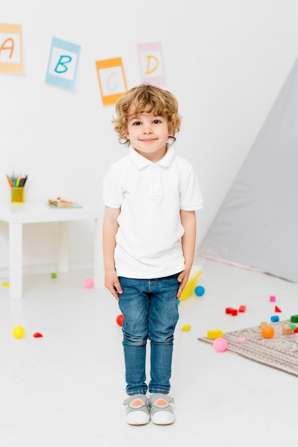 Gratis foto vooraanzicht van het jonge jongen stellen thuis