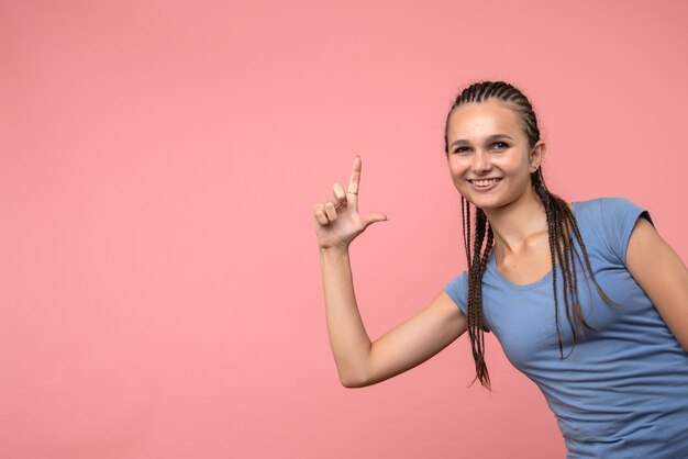 Vooraanzicht van het jonge wijfje dat op roze glimlacht