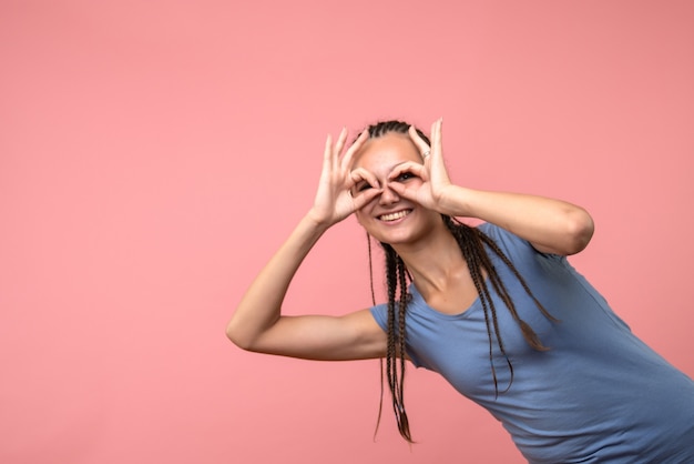 Gratis foto vooraanzicht van het jonge wijfje dat op roze glimlacht