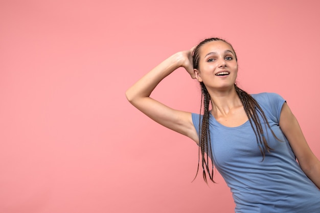 Vooraanzicht van het jonge wijfje dat op roze glimlacht