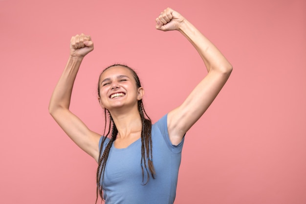 Gratis foto vooraanzicht van jong wijfje dat zich op roze verheugt