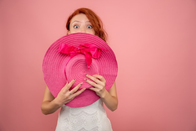 Vooraanzicht van jong wijfje met roze hoed op roze muur