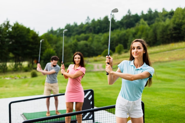 Vooraanzicht van jonge golfers met stok omhoog