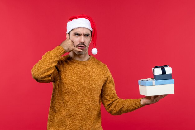 Vooraanzicht van jonge man die telefoongesprek op de rode muur imiteert