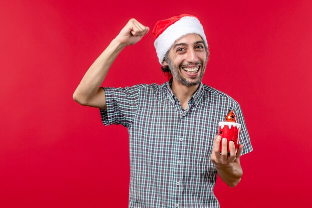 Vooraanzicht van jonge man met klein vakantiespeelgoed op rood