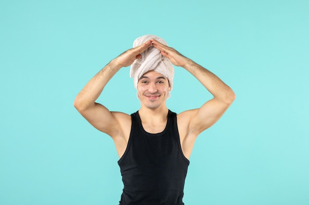 vooraanzicht van jonge man na douche op blauwe muur