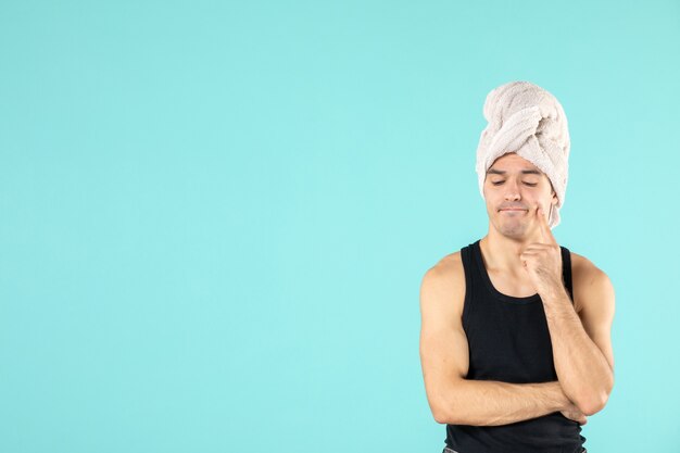 vooraanzicht van jonge man na douche op blauwe muur