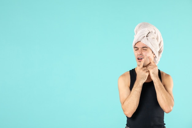 vooraanzicht van jonge man na douche op blauwe muur