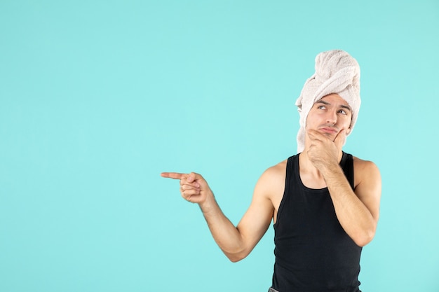 vooraanzicht van jonge man na douche op blauwe muur