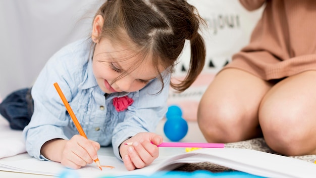 Gratis foto vooraanzicht van jonge meisjestekening thuis