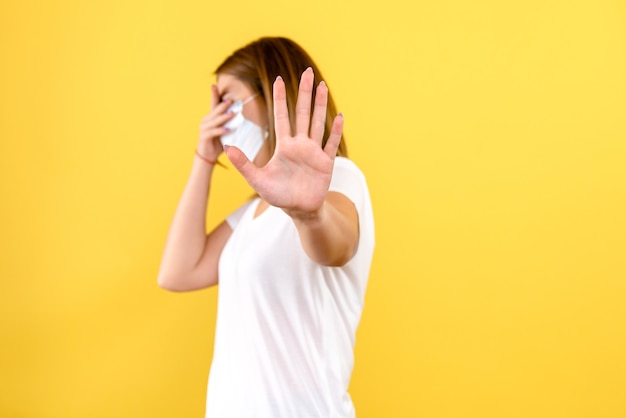 Gratis foto vooraanzicht van jonge vrouw beklemtoond op gele muur