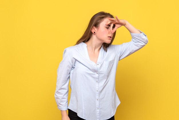 Vooraanzicht van jonge vrouw die haar neus knijpt