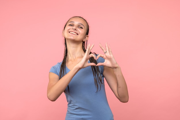 Vooraanzicht van jonge vrouw die liefde op roze verzendt