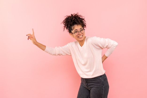 Vooraanzicht van jonge vrouw die op de roze muur glimlacht