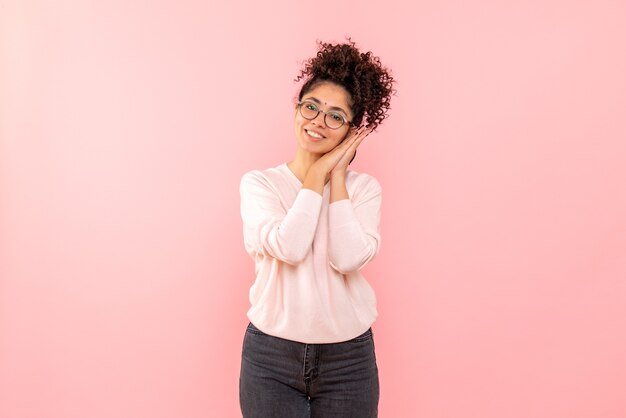 Vooraanzicht van jonge vrouw die op de roze muur glimlacht