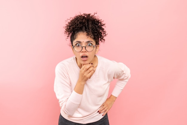 Vooraanzicht van jonge vrouw die op roze muur wordt verrast