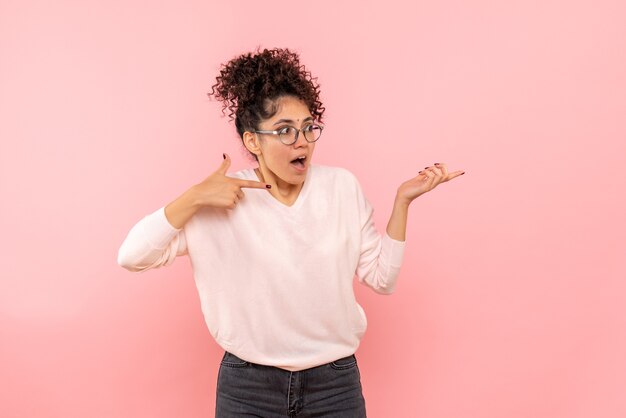 Vooraanzicht van jonge vrouw die op roze muur wordt verrast