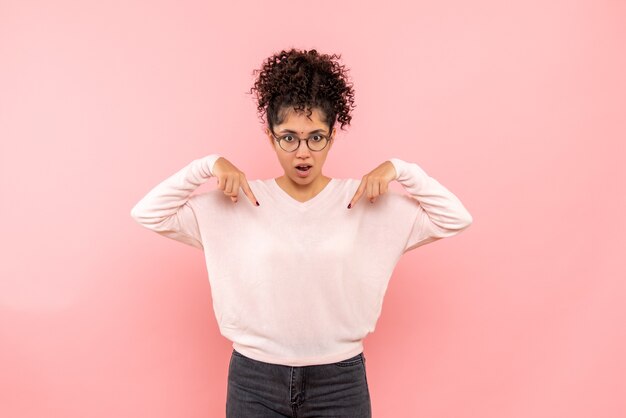 Vooraanzicht van jonge vrouw die op roze muur wordt verrast