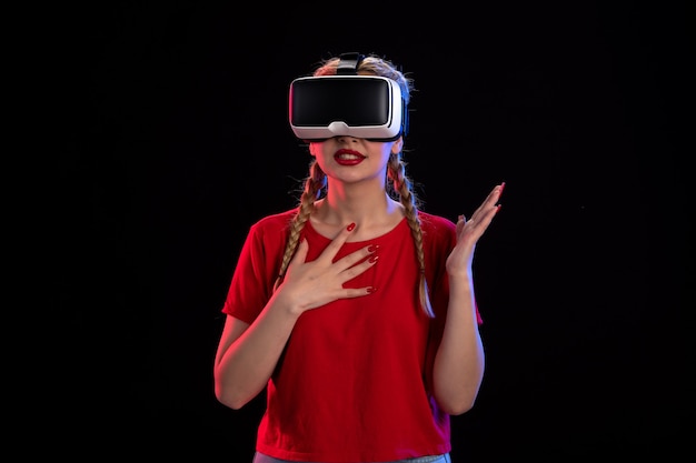 Vooraanzicht van jonge vrouw die virtual reality speelt op donkere visual